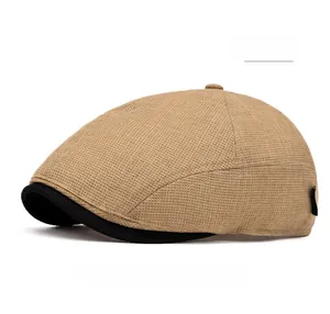 Detail of khaki plaid flat cap with contrasting black brim and side woven label