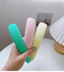 Detailed set of three plush sponge headbands in pastel green, pink, and yellow colors