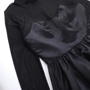 Detail of the black sheer mesh sleeve and satin fabric stitching on the dress