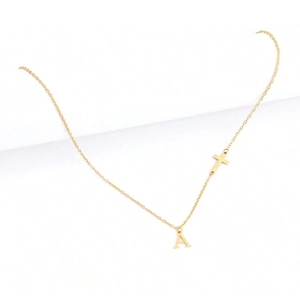 Detail view of gold cross necklace with personalized letter A pendant on white background