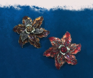 Detailed macro view of vintage flower brooches with enamel petals and shiny rhinestones