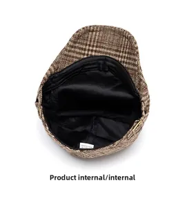 Detail view of the brown plaid ivy cap featuring soft inner lining and metal buckle