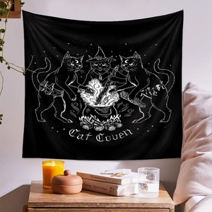 Detail of a Cat Coven tapestry with black cats and cauldron in a cozy room setting