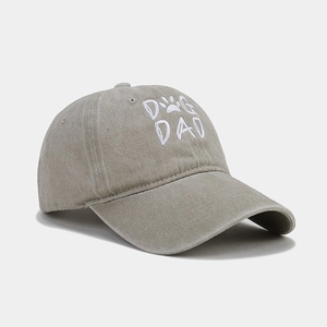 Detailed close-up of Dog Dad embroidery on light grey washed cotton baseball cap