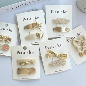 Golden heart and bow hair clip set with sequins for children on white background