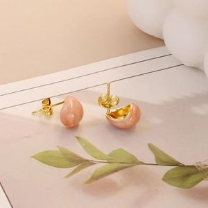 Detail view of pink teardrop marble studs with golden stainless steel butterfly backings