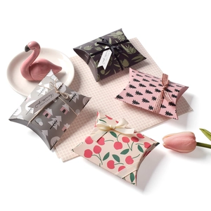 Flat lay of mini forest-style paper pillow boxes with cherry and tree patterns