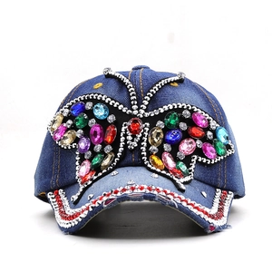 Blue denim baseball cap with a large colorful rhinestone butterfly and studded brim
