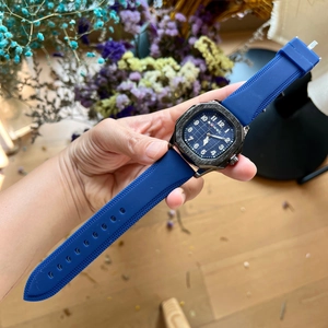 Close-up of a men's square watch with blue silicone strap and textured blue dial