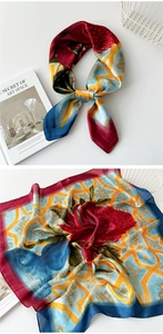 Detail of silk scarf with red floral patterns and blue geometric textures on satin fabric