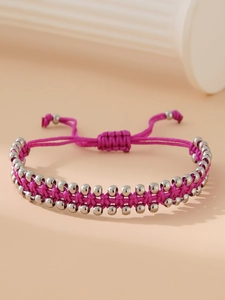 Détail du bracelet tressé rouge rose avec des perles en acier inoxydable et cordon ajustable