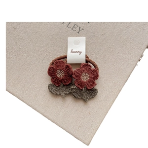 Cute crochet flower hair ties with red yarn petals and green leaves for girls