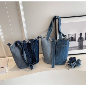 Detail of denim patchwork bucket bags in dark and light blue with detachable shoulder straps
