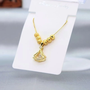 Detail of a gold fan-shaped pendant necklace with sparkling zircons and small gold beads