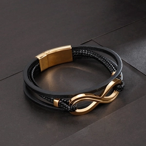 Vista macro di un bracciale multistrato in pelle intrecciata con fibbia a infinito oro