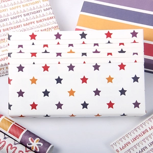 Colorful gift wrapping paper with star patterns, stripes and Happy Birthday text rolls