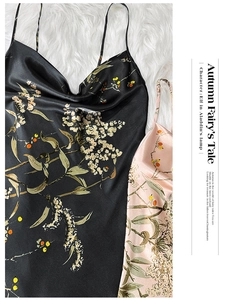 Close-up of silk satin slip dresses with autumn floral print on a white faux fur background