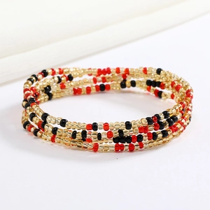 Detail of multi-layered red, black, and gold beaded elastic waist chain or bracelet
