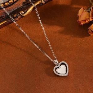 Gros plan sur collier cœur en argent avec diamants brillants et incrustation nacre blanche