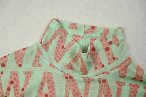 Detail of high neck mesh dress with mint green fabric and pink polka dot letter prints