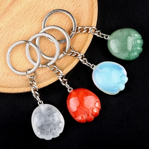 Natural crystal agate cat paw keychains in four colors on a wooden and black background