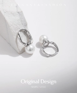 Macro shot of S925 sterling silver twisted hoop earrings with elegant white round pearls