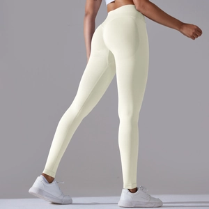 Detailed close-up of cream high-waist seamless yoga pants with peach lift contouring