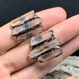 Macro shot of handmade raw white crystal earrings with antique bronze copper wrapping