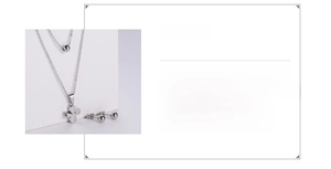 Détail d'un ensemble collier double chaîne et boucles d'oreilles en acier titane plaqué or 18k