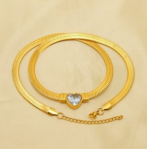 Detail of 18K gold-plated herringbone chain with a heart-shaped zircon pendant on silk
