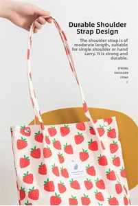 Primer plano detallado del bolso de pana con bonito estampado de fresas y asas.