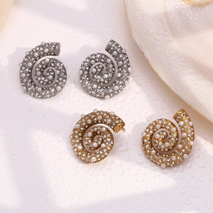 Detailed macro shot of conch shell earrings in gold and silver with pearls and zircons