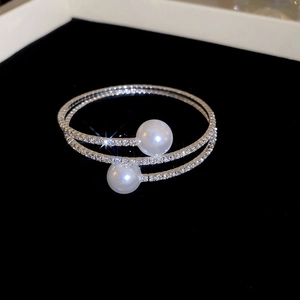 Dettaglio macro del bracciale a spirale in argento con grandi perle e pavé di zirconi