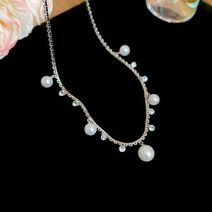 Close-up of pearl necklace with rhinestone fringe on black velvet for high-end look