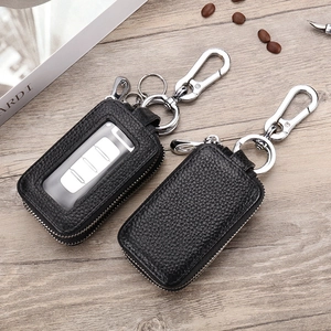 Dual-layer lychee grain leather key case with metal hook on a rustic wooden table