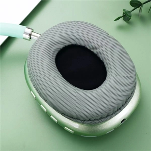 Detailed close-up of green wireless headphone ear cup with soft grey fabric cushion