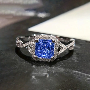 Vue rapprochée d'une bague en argent avec une pierre bleue carrée et des diamants