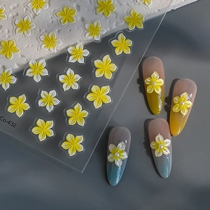 Adesivi per unghie 3D con fiori di frangipane gialli e perle su sfondo grigio scuro