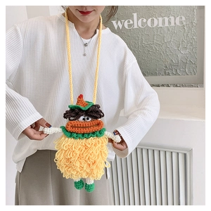 Detail of yellow handmade knit crossbody bag with cute sausage mouth cartoon design
