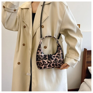 Fashionable leopard print patent leather handbag worn with a beige trench coat