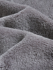 Close-up of thick grey coral fleece fabric showing soft texture and high-density plush pile