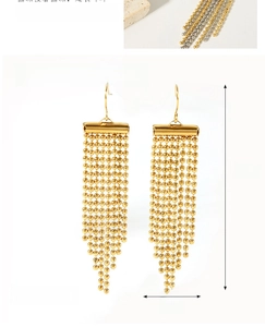 Détail de boucles d'oreilles à pompons en acier doré 18K mesurant 75 mm de long