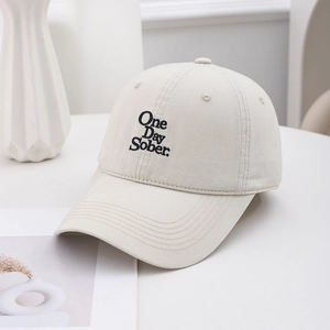 Close-up of One Day Sober black embroidery on high-density beige cotton baseball cap