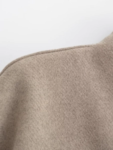 Détail de couture d'épaule et texture laineuse du manteau camel ample à col en V