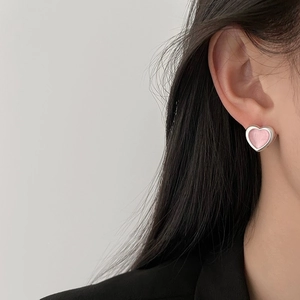 Elegant sweet pink heart stud earrings with silver border worn by model in a minimalist style