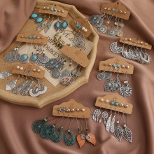 Flat lay of diverse earring set featuring butterflies, pearls and turquoise on display cards