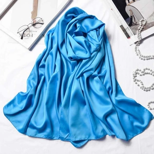 Blue matte satin silk scarf 180x70cm displayed with elegant accessories on a white base