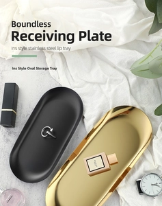Detail of matte black and glossy gold stainless steel oval trays on white fabric