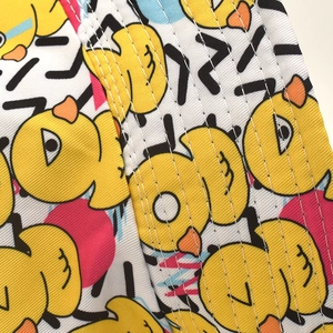 Vue détaillée du motif canard jaune et de la double couture blanche sur le bob