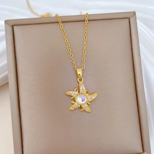 Luxurious gold starfish pendant necklace with sparkling crystals on elegant silk background